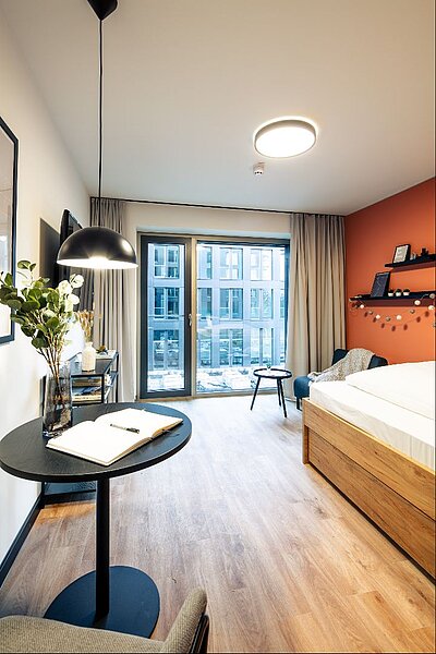 Im Apartment wurde der große Schreibtisch durch einen kleinen Tisch und ein Sesselelement ersetzt. © Abeetz